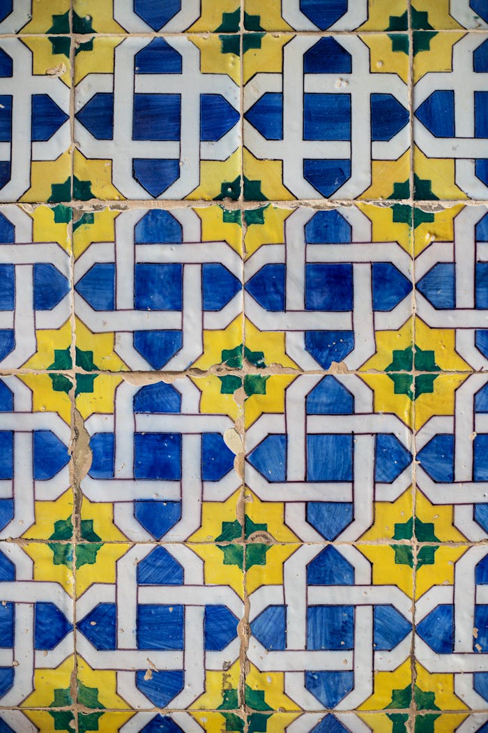 Detailed view of traditional Portuguese azulejos in Lisbon featuring geometric patterns in blue, yellow, and green.