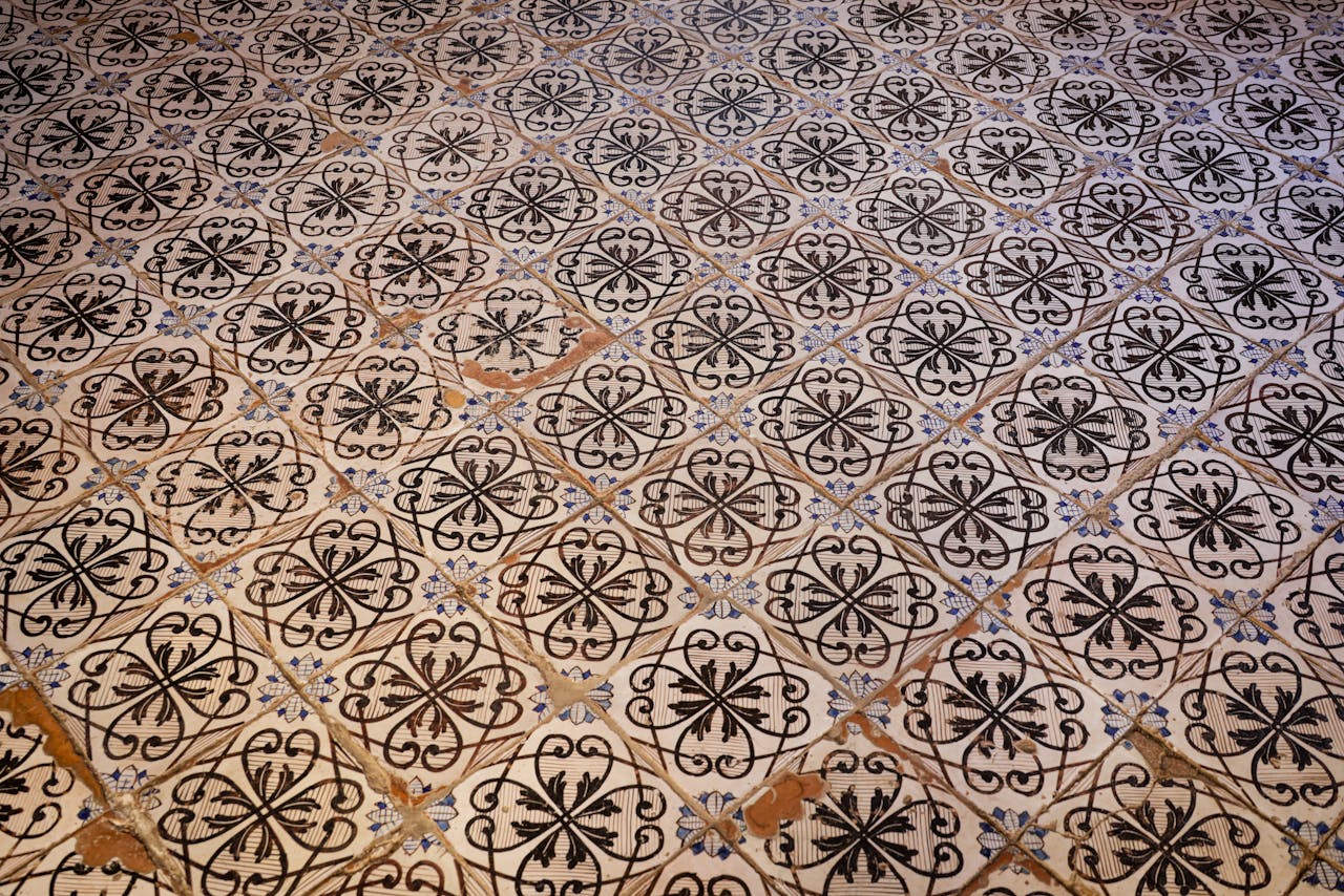 Ornate vintage tiles with intricate black floral designs indoors.